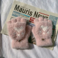 Rosa flauschige Fingerlose Handschuhe auf Zeitung, Wintermode Accessoire, Damenbekleidung.