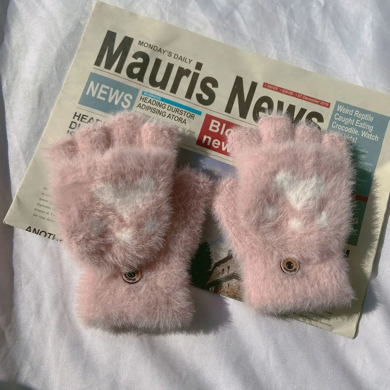 Rosa flauschige Fingerlose Handschuhe auf Zeitung, Wintermode Accessoire, Damenbekleidung.