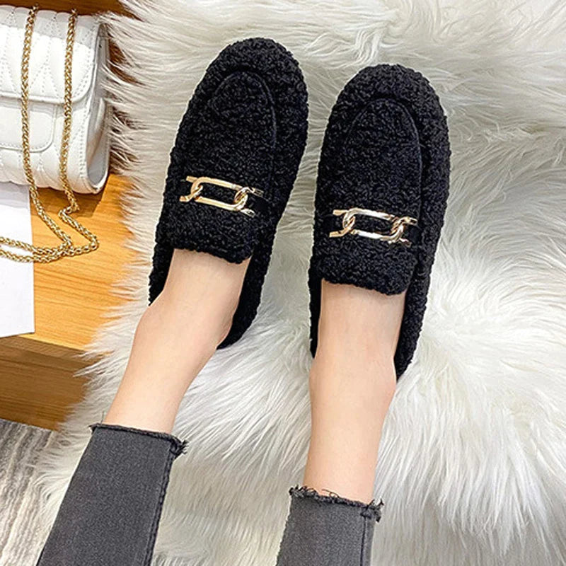 Schwarze Damen-Loafer mit goldener Kette, flauschig, modisch, bequem, auf Teppich.