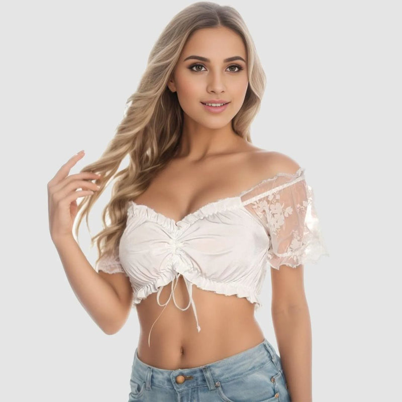 Frau in weißem Spitzen-Crop-Top, schulterfrei, mit blonden Haaren, modisch, elegant.