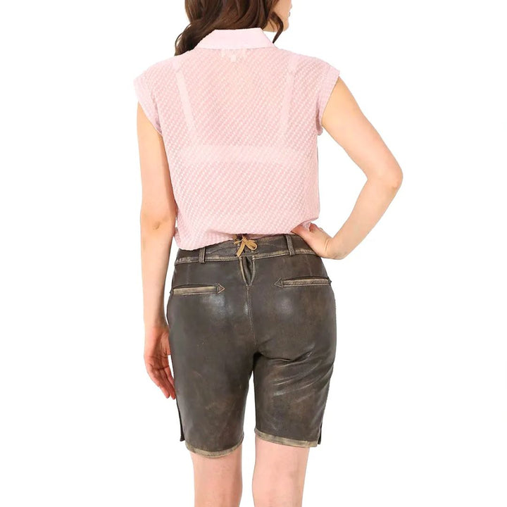 Frau in rosa Bluse und brauner Lederhose von hinten, Trachtenmode, traditionell, elegant.