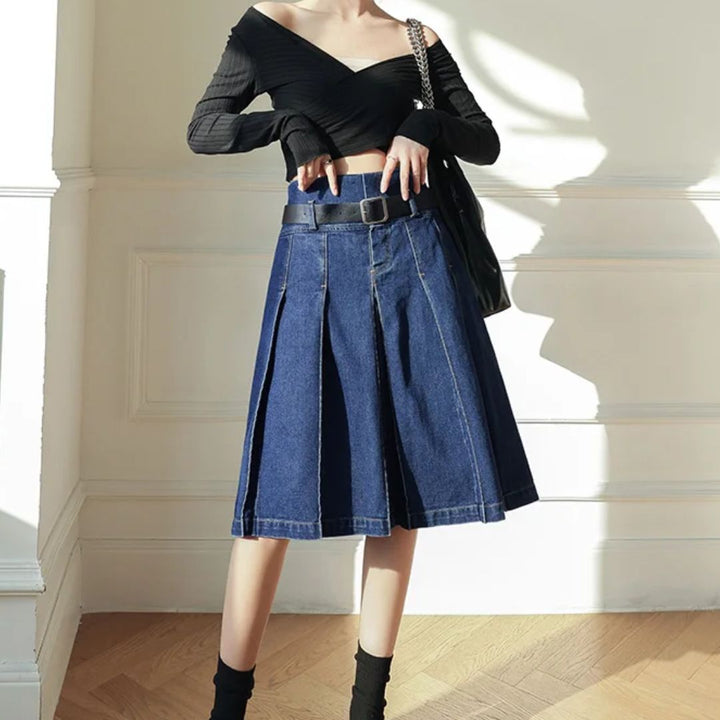 Damenmode: Schwarzes Off-Shoulder-Top und blauer Jeansrock mit Falten, eleganter Look.