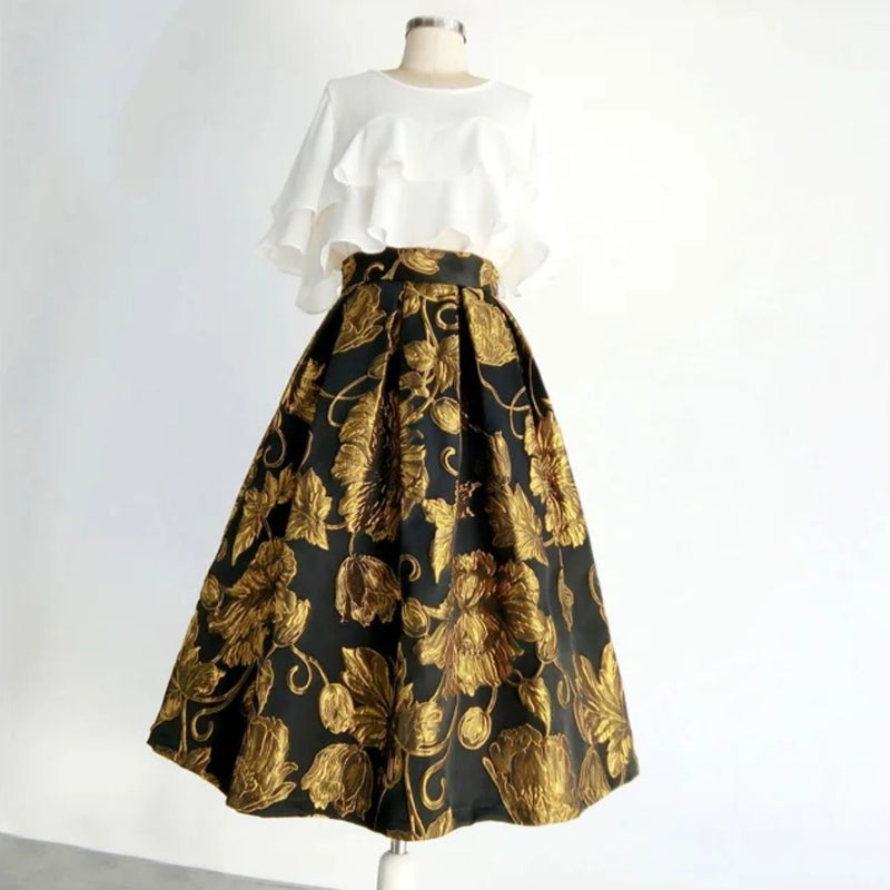 Schneiderpuppe mit weißer Rüschenbluse und schwarzem Rock mit goldenen Blumenmuster.