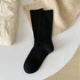 Schwarze Baumwollsocken auf weißem Tisch, modisch, bequem, für Damen und Herren.
