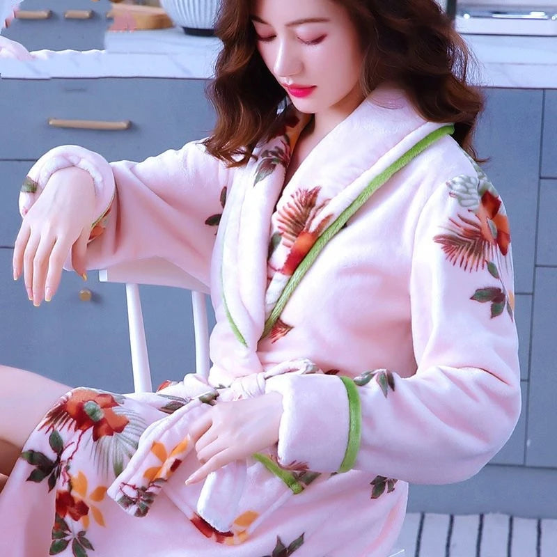Frau im rosa Bademantel mit Blumenmuster, weiches Material, gemütlich, modisch, Damenbekleidung.