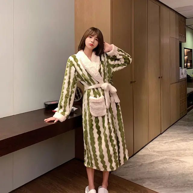 Frau in grün-weißem gestreiftem Bademantel mit Gürtel, flauschig, gemütlich, modernem Innenraum.