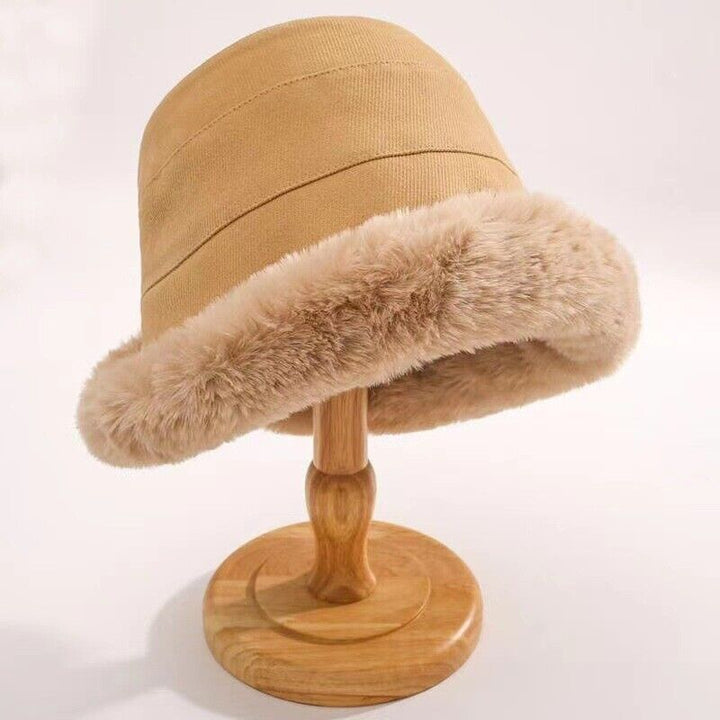 Beiger Damenhut mit Kunstfellrand auf Holzständer, Wintermode, elegant, warm, Accessoire.