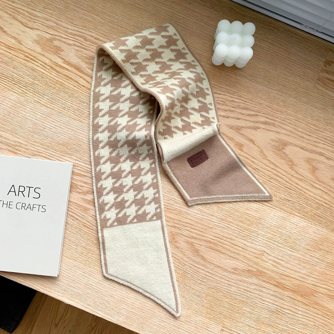 Beige-weißer Hahnentritt-Schal aus Wolle auf Holztisch, modisches Accessoire.