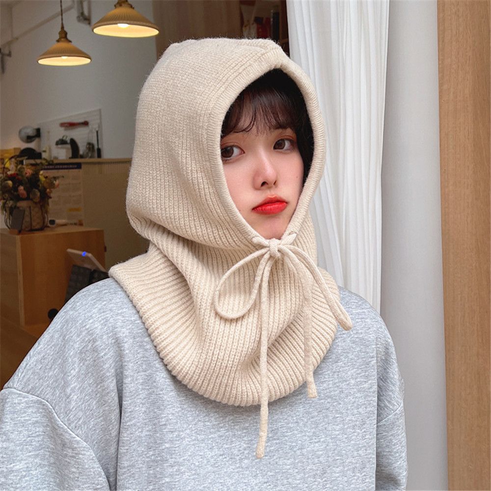 Frau mit beigem Strickschal-Kapuze, gemütlich, modisch, Herbst-Winter-Accessoire.