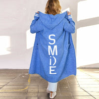 Frau in blauem Hoodie mit "SMILE"-Aufdruck, Kapuze, lässiger Stil, Rückansicht.