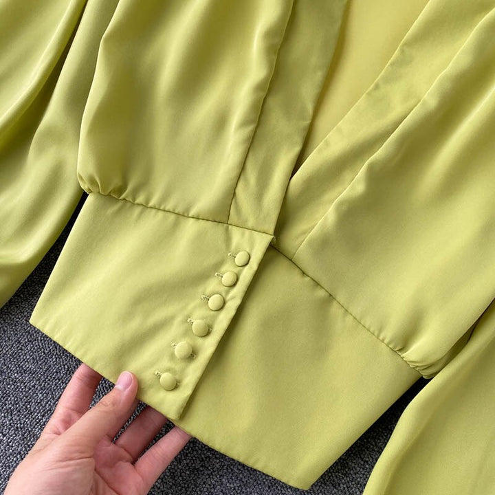 Gelbe Bluse mit Knopfleiste, elegantes Design, Damenmode, Satinmaterial, Nahaufnahme.