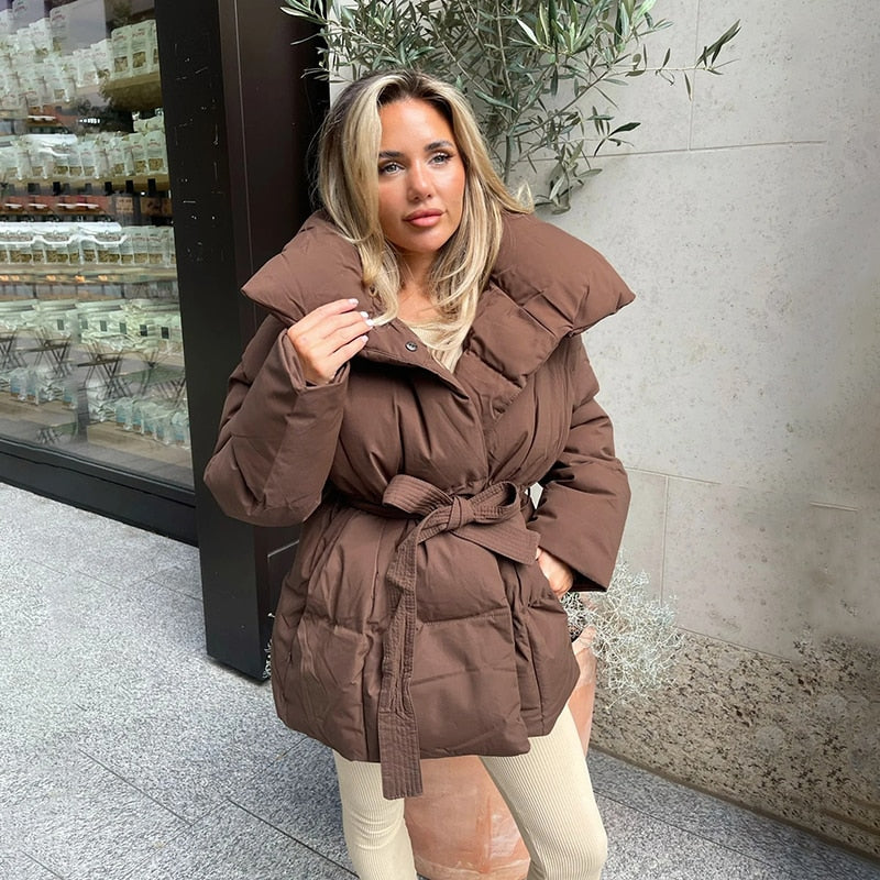 Frau in brauner Daunenjacke mit Gürtel, Wintermode, Outdoor, modern, stilvoll, warm.