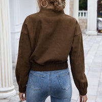 Frau in brauner Jacke und blauer Jeans, Rückansicht, modisch, lässig, Herbstmode.