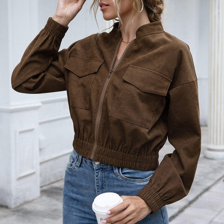 Frau in brauner Wildlederjacke, lässig, modisch, Herbstmode, Kaffeebecher, Jeans.