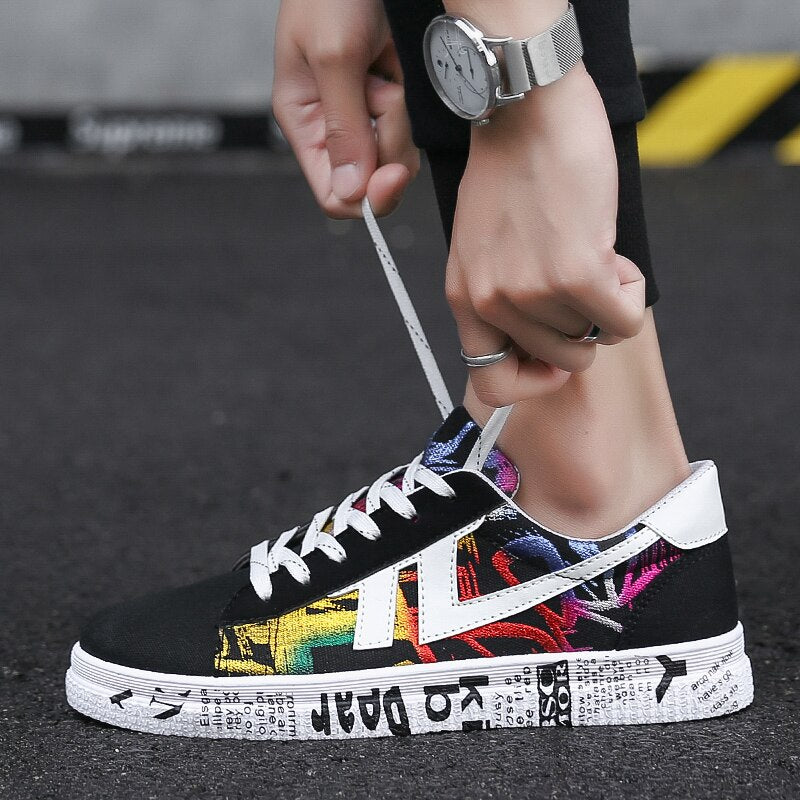 Schwarzer Sneaker mit buntem Graffiti-Design, weiße Sohle, Schnürsenkel, Unisex-Straßenschuh.