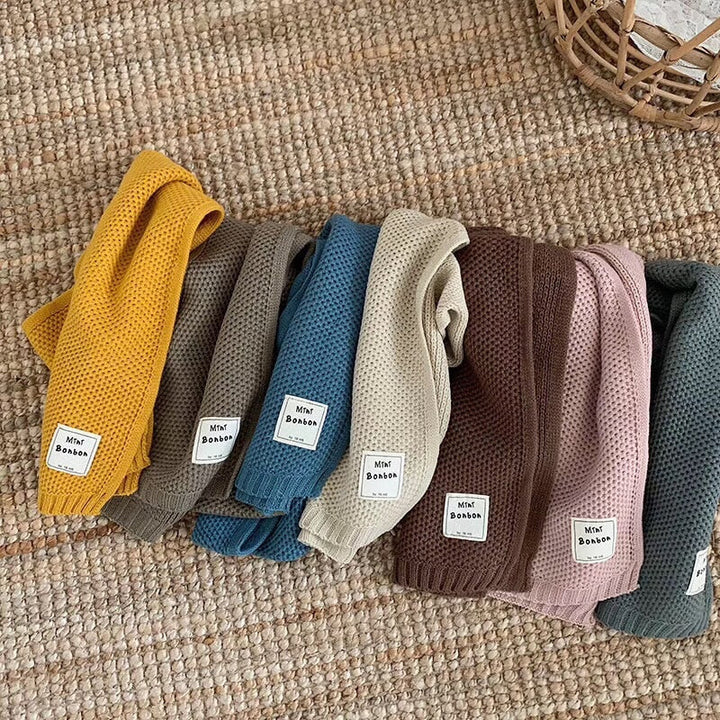 Verschiedene bunte Babystrumpfhosen aus Baumwolle auf Teppich, Mini Bonbon Etikett.