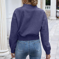 Frau in blauer Jacke und Jeans, Rückansicht, lässige Mode, Herbstkleidung, draußen.