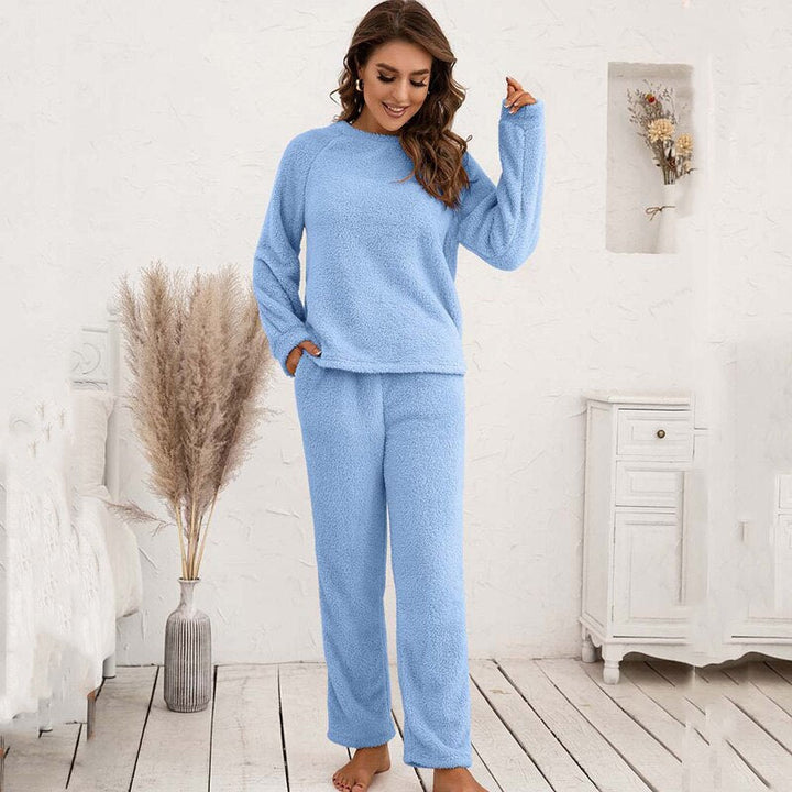 Frau in hellblauem Fleece-Pyjama-Set, gemütlich, langärmelig, Innenraum, Schlafzimmer.