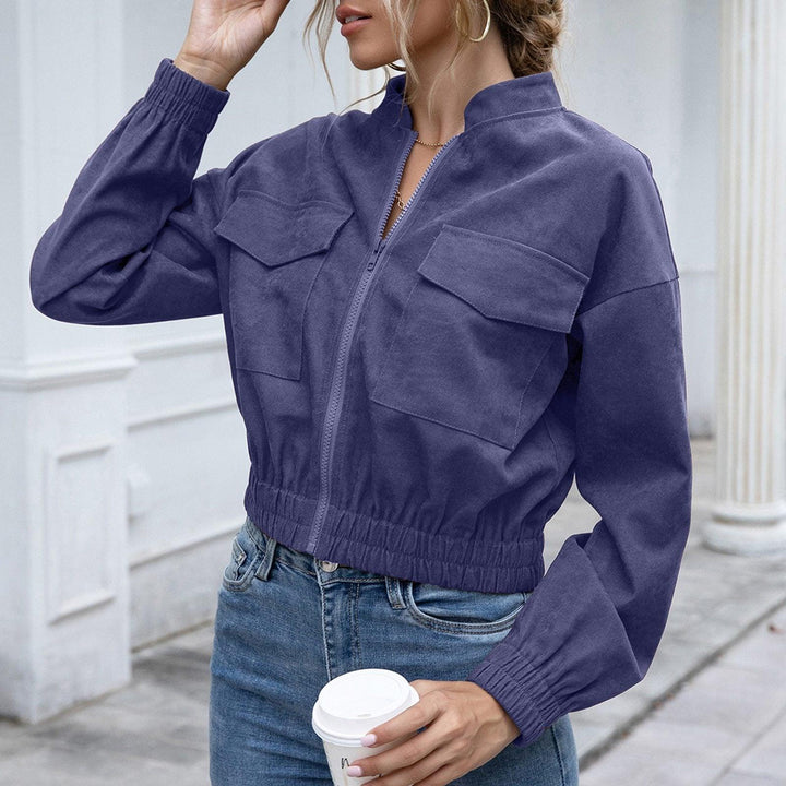 Frau in blauer Bomberjacke aus Baumwolle, hält Kaffeebecher, modische Freizeitkleidung.