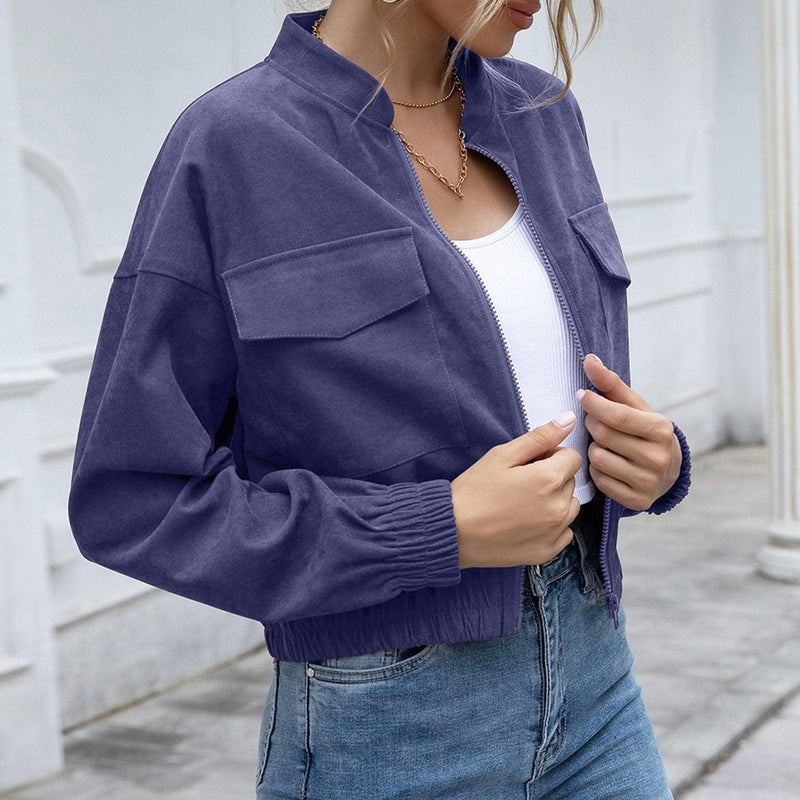 Frau in blauer Bomberjacke, weißem Top und Jeans, modisch, lässig, urbaner Stil.