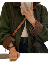 Dunkelgrüne Jacke mit braunem Kragen, Damenmode, Herbstoutfit, lässiger Stil.
