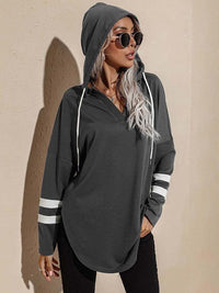 Frau in grauem Kapuzenpullover mit Streifen, Sonnenbrille, lässige Mode, Herbstoutfit.