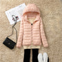 Damen Steppjacke rosa mit Kapuze, modisch, warm, Herbst Winter, auf Teppich mit Tasche und Zeitschrift.