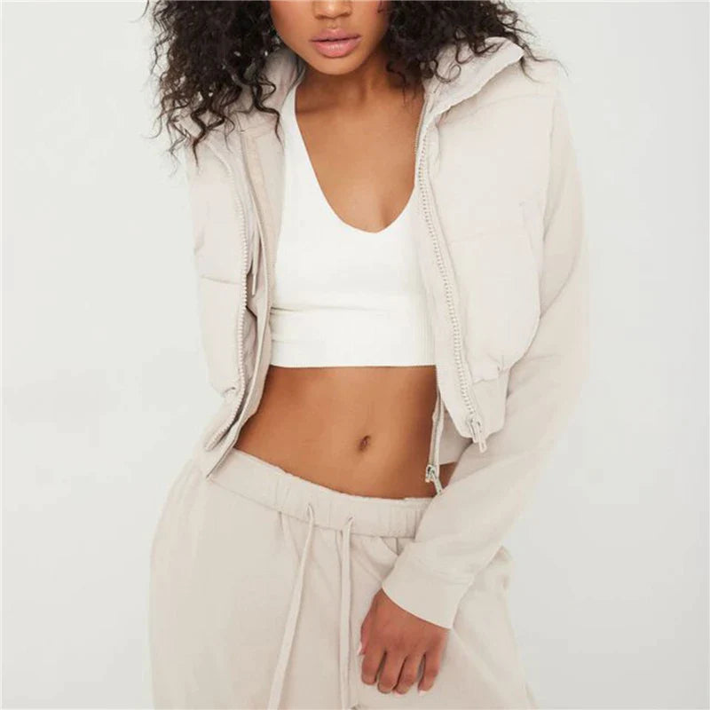 Frau in beigem Jogginganzug und weißem Top, sportlich, modisch, Freizeitkleidung.