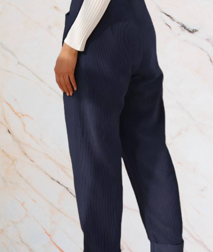 Dunkelblaue Damenhose, gerippt, elegant, aus Baumwolle, vor Marmorhintergrund.