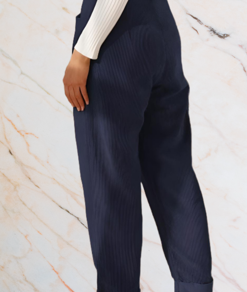 Dunkelblaue Damenhose, gerippt, elegant, aus Baumwolle, vor Marmorhintergrund.