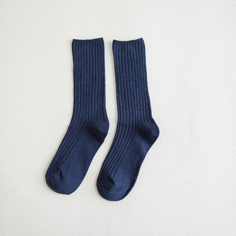 Dunkelblaue gerippte Socken aus Baumwolle, knielang, auf weißem Hintergrund.