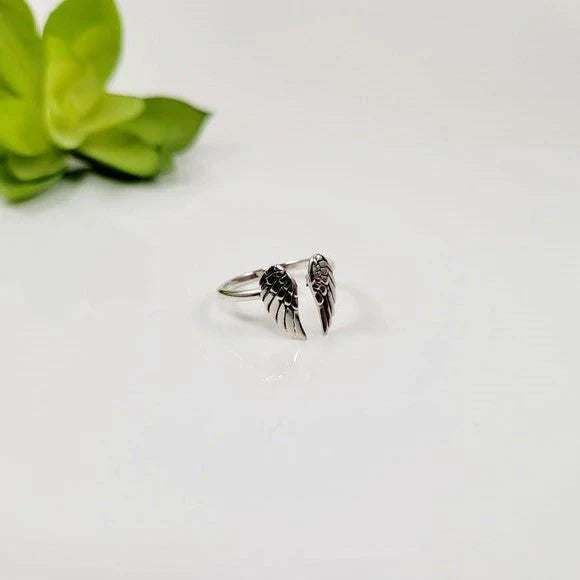 Silberner Engelsflügel-Ring auf weißem Hintergrund, Schmuck, Damenaccessoire, Geschenkidee.