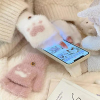 Weiße flauschige Handschuhe mit Katzenpfoten-Design, Smartphone, Wintermode Accessoire.