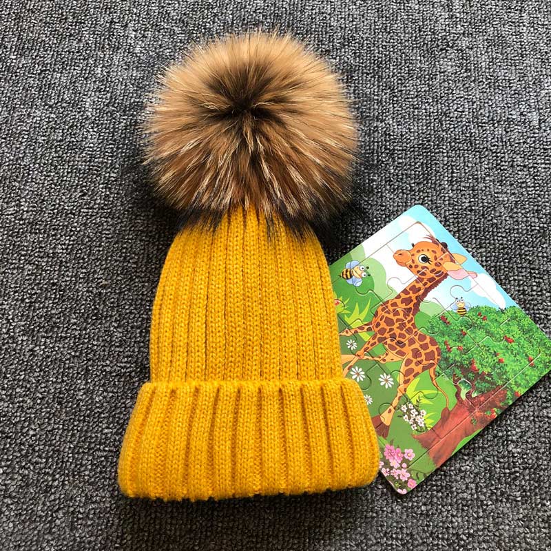 Gelbe Strickmütze mit Kunstfellbommel, Kinderpuzzle, Wintermode, warm, stilvoll, Accessoire.