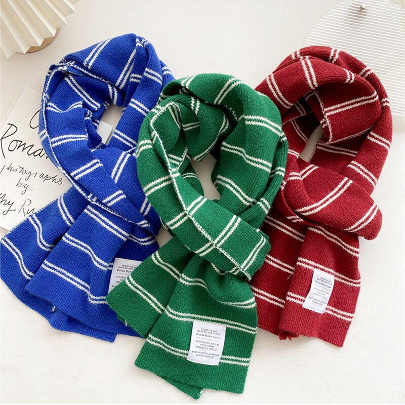 Drei gestreifte Schals in Blau, Grün und Rot aus Wolle auf weißem Hintergrund.