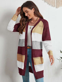 Frau trägt gestreifte Strickweste in Burgunder, Weiß, Grau und Gelb, lässiger Herbstlook.