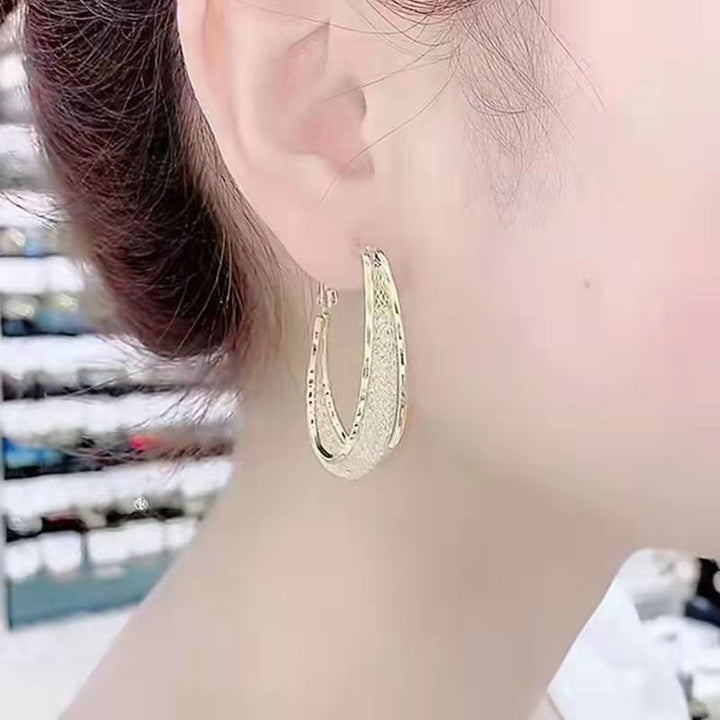 Goldene Creolen Ohrringe, gehämmertes Design, eleganter Schmuck für Damen, modisch und stilvoll.