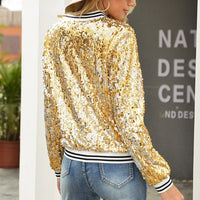 Frau in goldener Paillettenjacke und Jeans, modisch, glamourös, Outdoor-Hintergrund.
