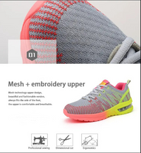 Grauer Sportschuh mit rotem und gelbem Akzent, Mesh-Obermaterial, Stickerei, ergonomisches Design.