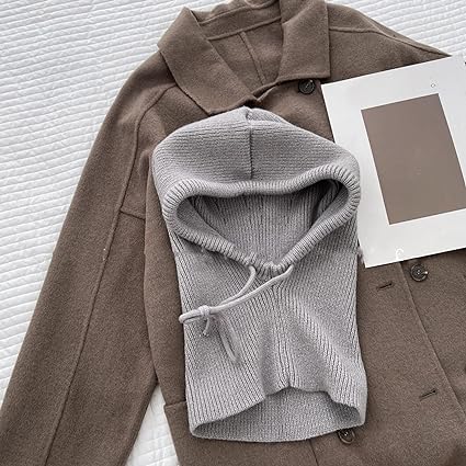 Grauer Strick-Balaclava auf braunem Wollmantel, modisches Winteraccessoire.