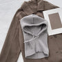 Grauer Strick-Balaclava auf braunem Wollmantel, modisches Winteraccessoire.
