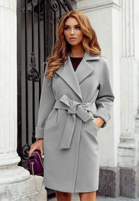 Frau in grauem Wollmantel mit Gürtel, elegante Herbstmode, Damenbekleidung, Stadtstil.