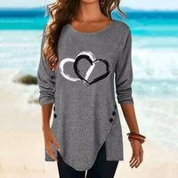 Graues Damen-Langarmshirt mit Herzmotiv, Knopfleiste, Strandhintergrund.