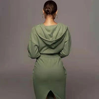 Frau in grünem Kapuzenkleid, Rückansicht, elegantes Design, Freizeitmode, Herbstkleidung.