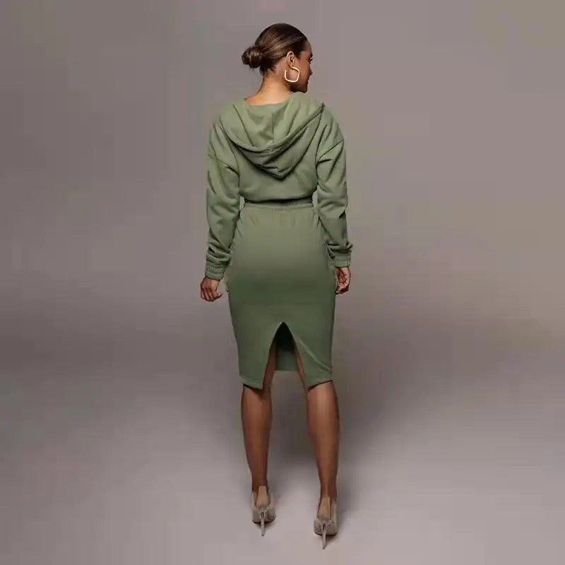 Frau in olivgrünem Kapuzenkleid, Rückansicht, elegantes Design, modische Damenbekleidung.