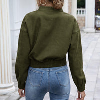 Frau in olivgrüner Jacke und blauer Jeans, Rückansicht, lässige Mode, Herbstoutfit.