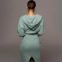 Frau in mintgrünem Kapuzenkleid aus Baumwolle, Rückansicht, modisch, bequem, Freizeitkleidung.