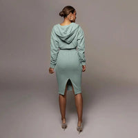 Frau in mintgrünem Kapuzenkleid, Rückansicht, elegantes Design, knielang, modisch.