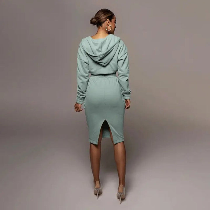 Frau in mintgrünem Kapuzenkleid, Rückansicht, elegantes Design, knielang, modisch.