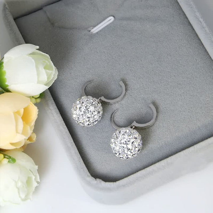 Silberne Ohrringe mit Kristallen in grauer Schmuckschatulle, eleganter Schmuck für Damen.